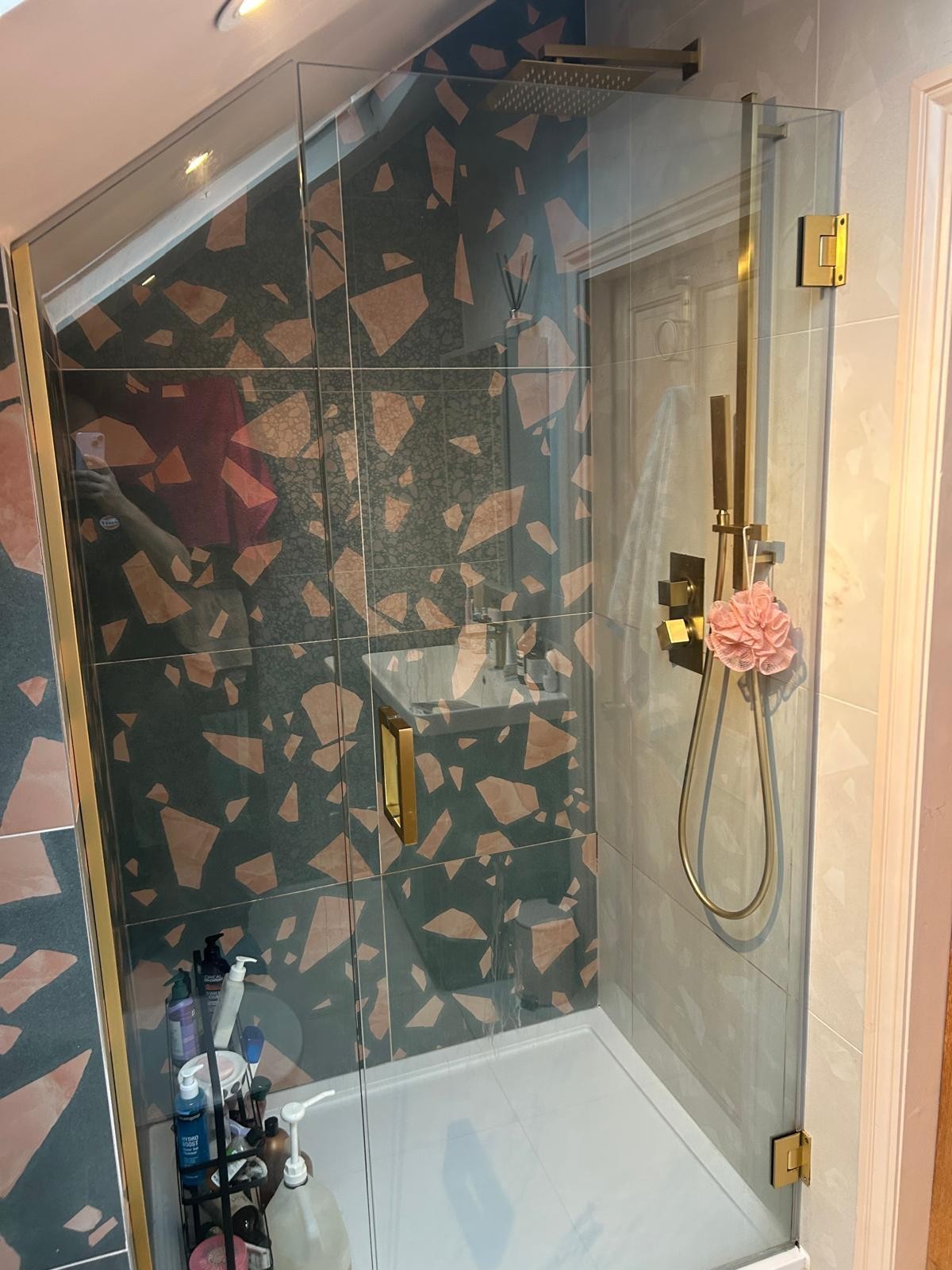Walk-in shower enclosure with brass rainfall shower and terrazzo tiling fitted on a Manchester bathroom installation