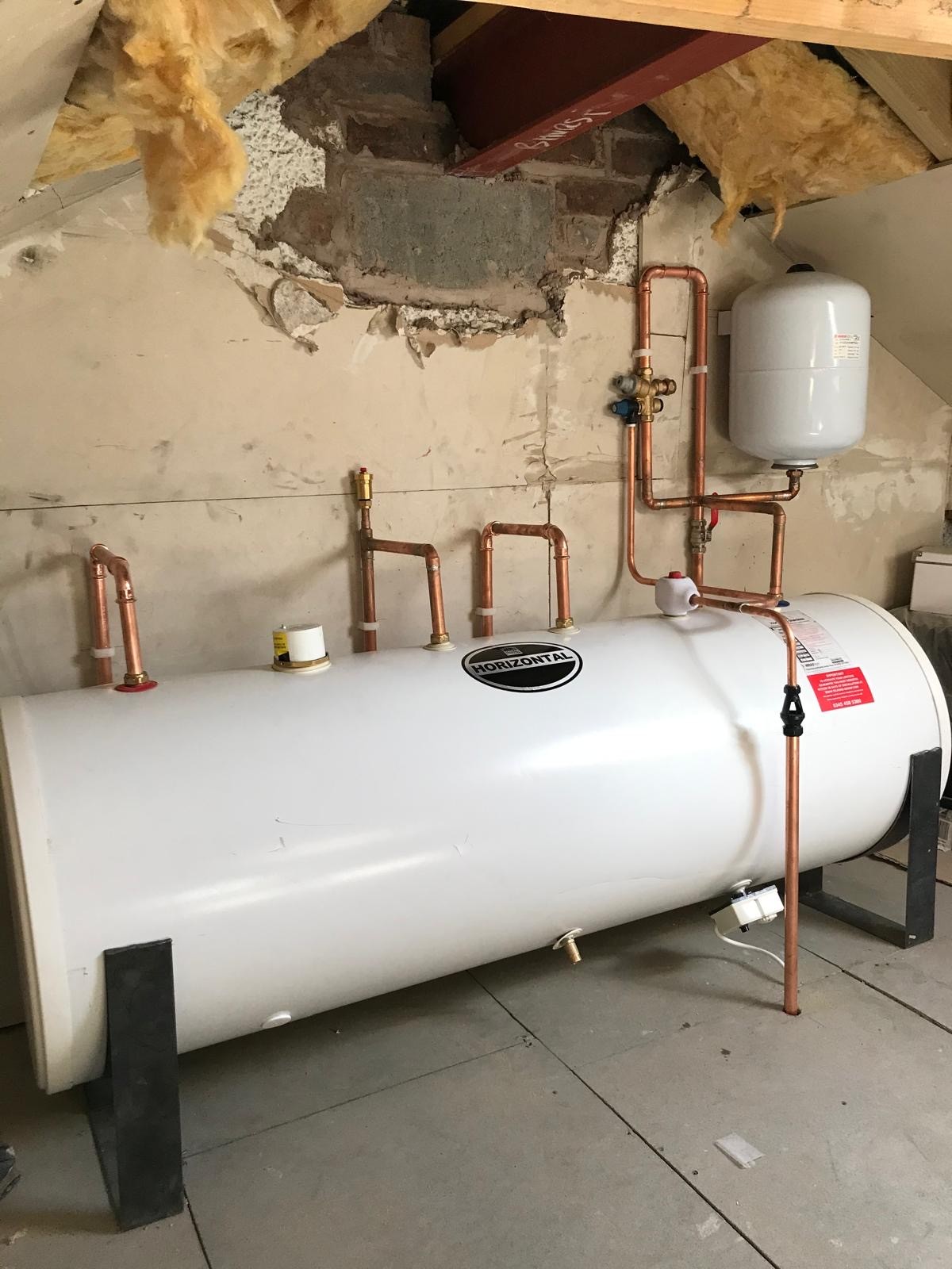 Horizontal unvented hot water cylinder installed in a loft space in Manchester