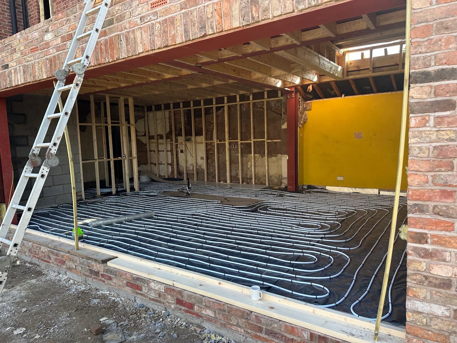 Underfloor heating pipe loops laid over insulation before screeding on a Manchester extension