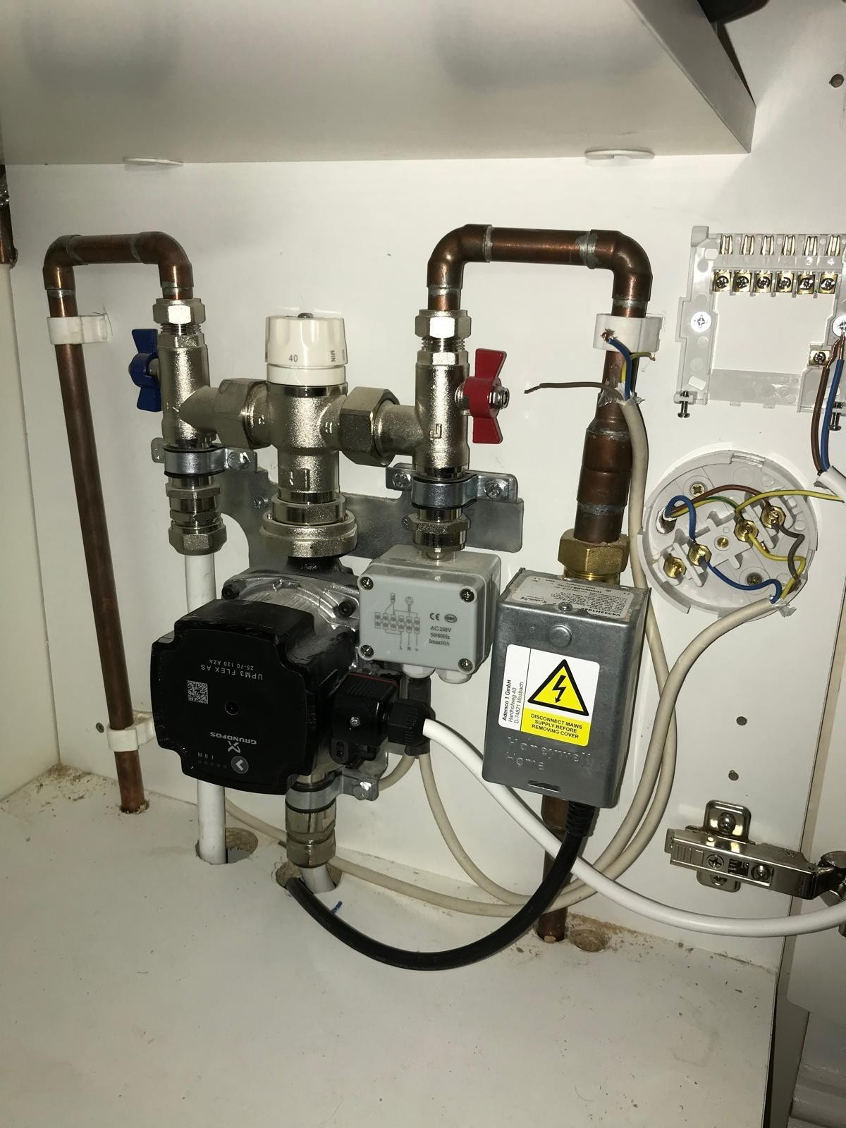 Grundfos pump, blending valve and isolation valves in a heating cupboard during an emergency call-out in Manchester