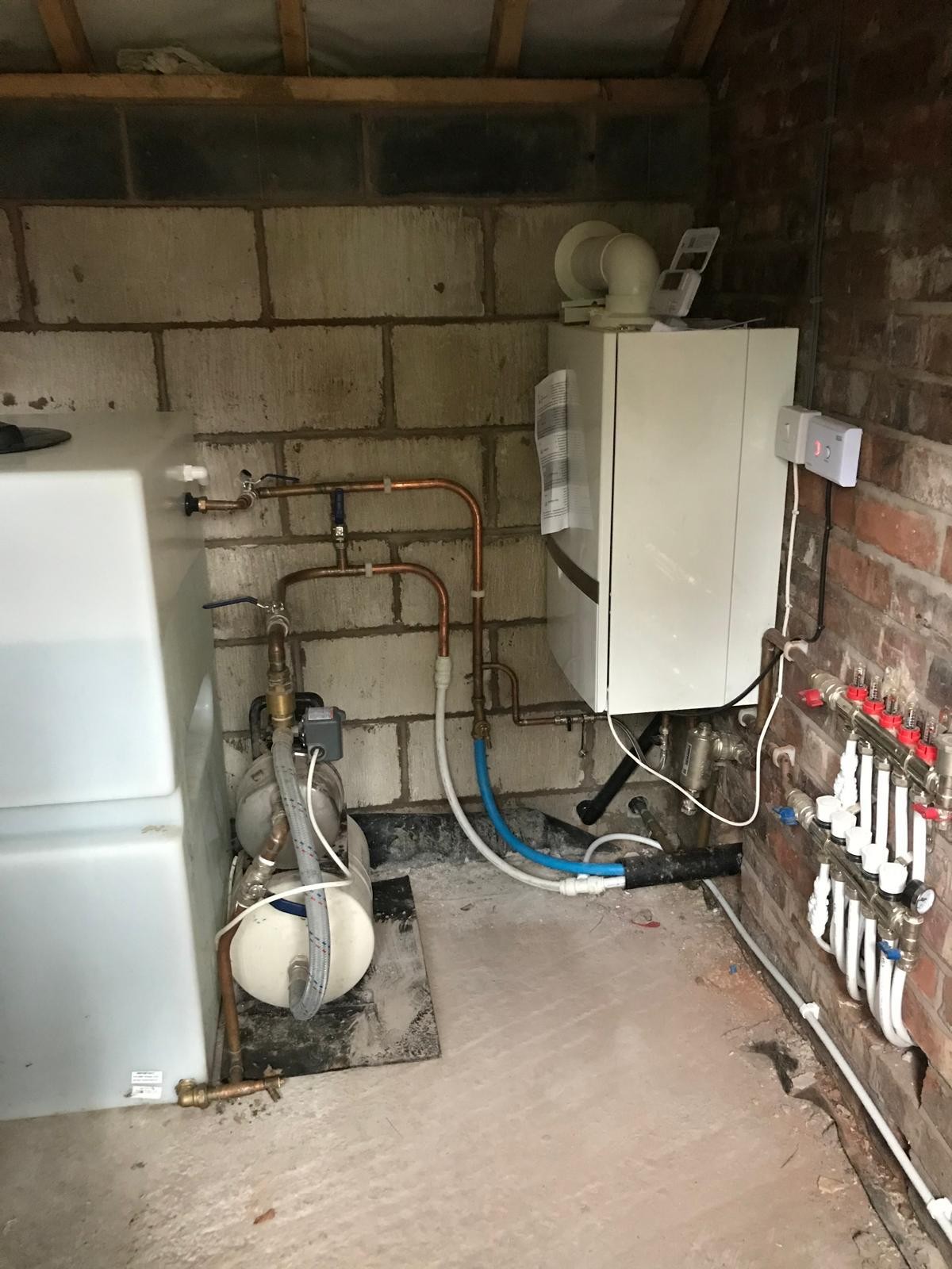 Central heating system boiler and expansion vessel installed in a brick utility space in Manchester