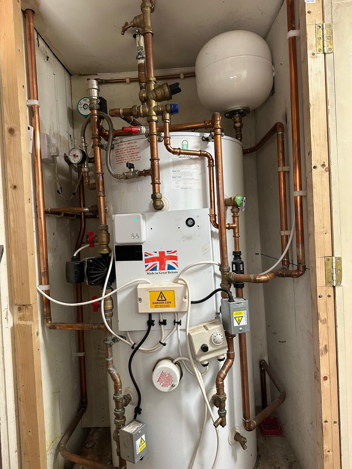 Hot water cylinder installed inside an airing cupboard in a Trafford home